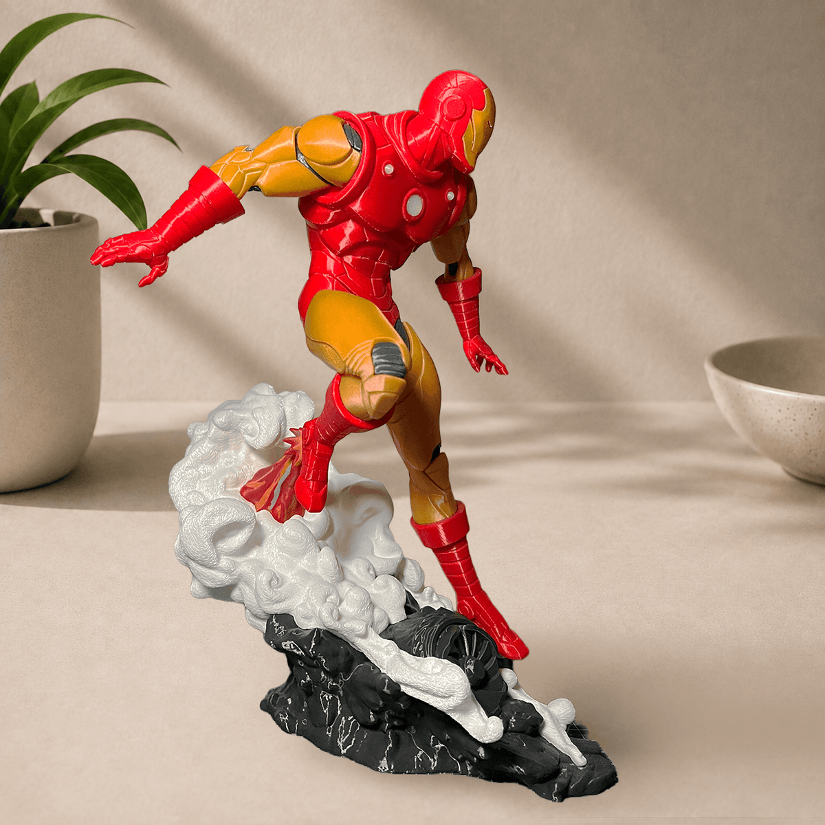 Side view of the 3D-printed classic 1963 comics-style Iron Man figurine in red and gold armor, posed leaping off a smoking rock base.