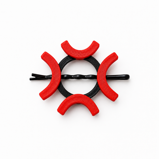 A black twisted bobby pin hair clip decorated with six red crescent-shaped plastic covers, arranged in a circular pattern on a solid white background.