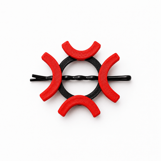 A black twisted bobby pin hair clip decorated with six red crescent-shaped plastic covers, arranged in a circular pattern on a solid white background.