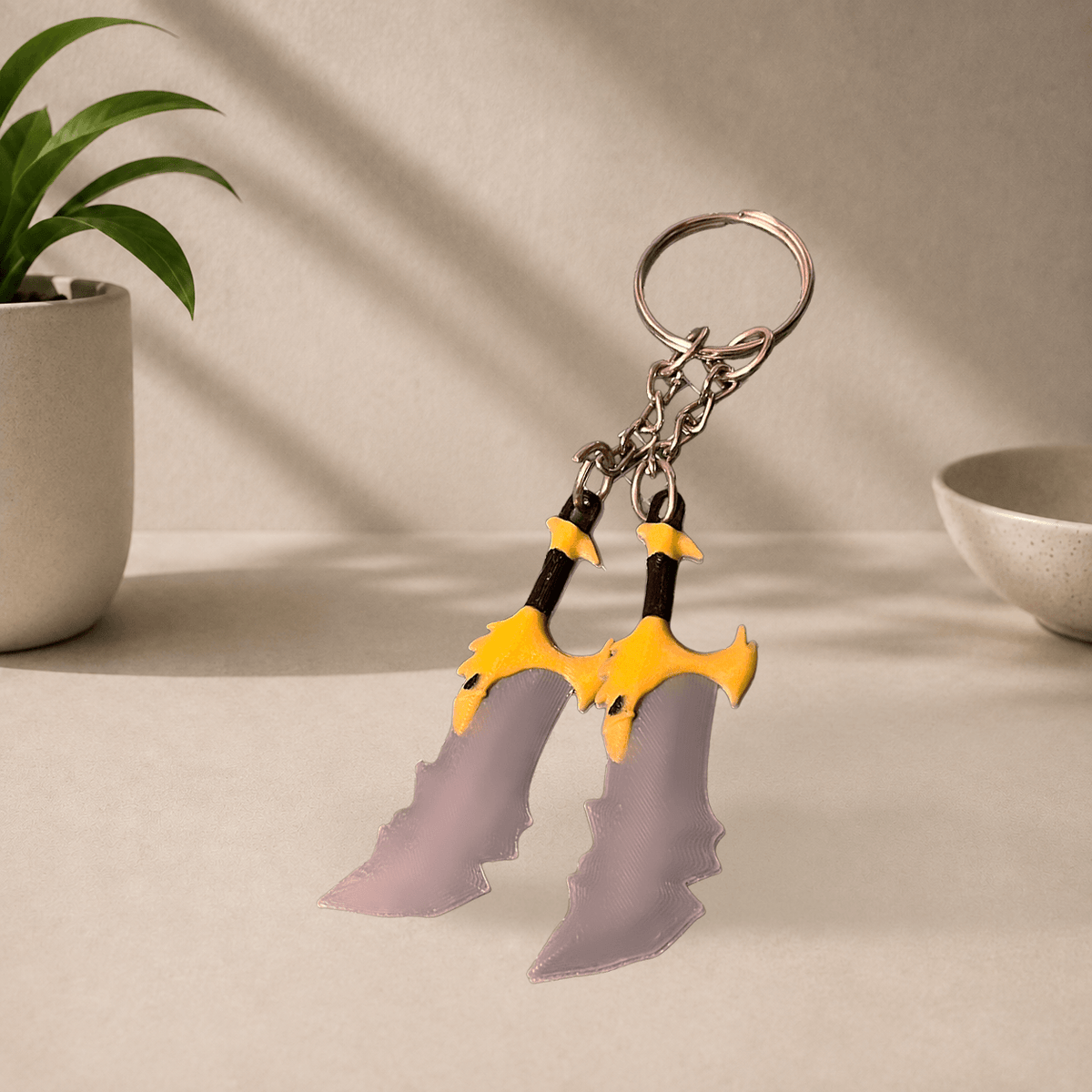 Pair of 3D-printed Blades of Chaos keychain charms (God of War) in plain gray without blood detailing, hanging from a metal keyring.