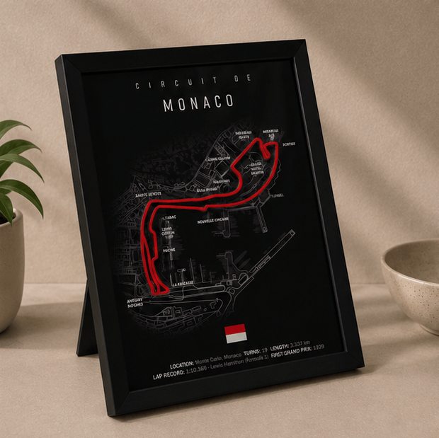 Angled close-up of the framed Circuit de Monaco F1 track print, showing the black frame edge and red circuit layout.