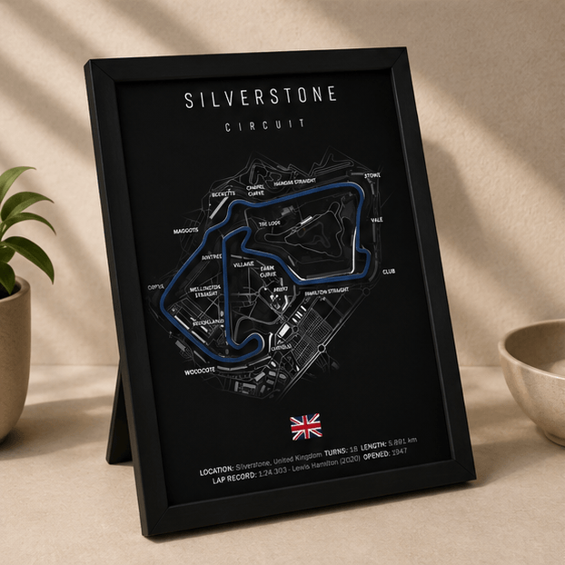 Angled view of the framed Silverstone Circuit F1 track print, showing the blue circuit outline and UK flag on a black background.