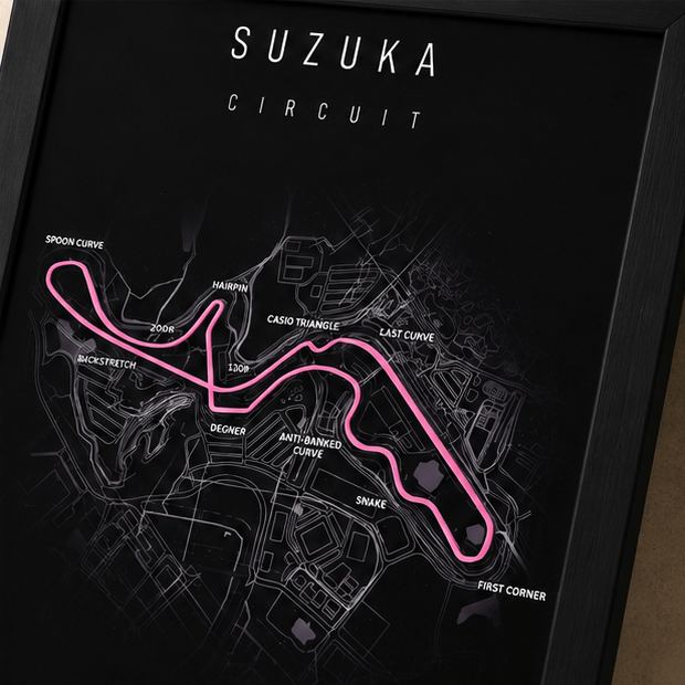 Close-up of the Suzuka Circuit F1 track print with corner names labeled, including Degner, Casio Triangle, and the hairpin, on a black background.