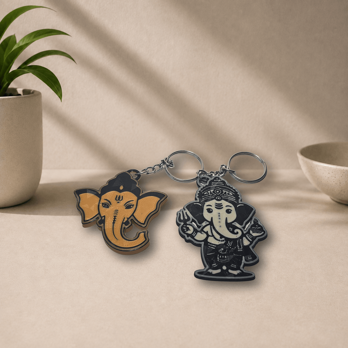 Two 3D-printed Ganesha keychain designs shown together