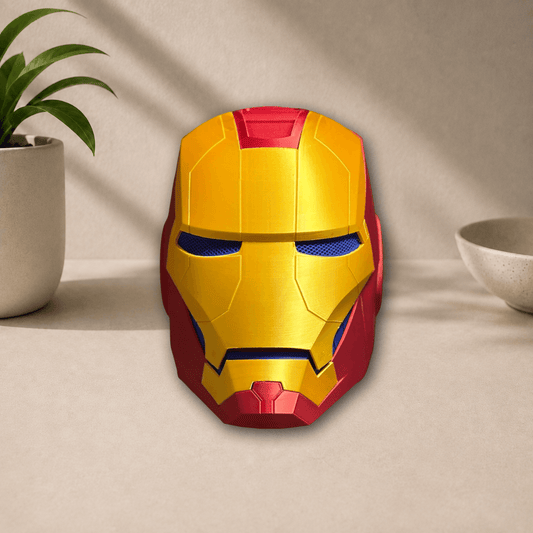 Gold and red 3D-printed Iron Man cosplay helmet with blue-lit eye lenses, front view on a beige tabletop.