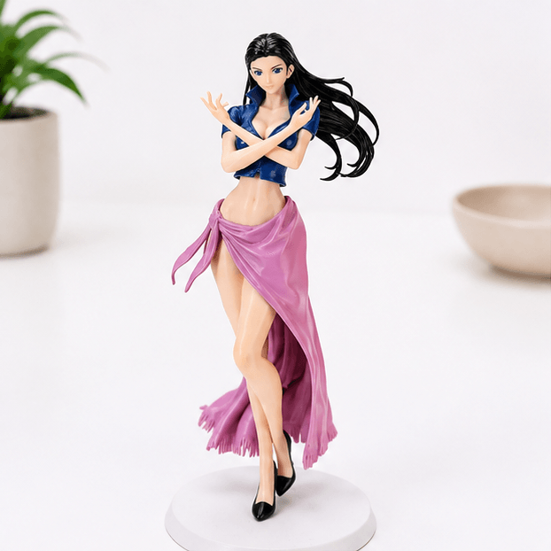 Full-length view of a Nico Robin One Piece statue standing on a round white base, wearing a blue crop top, flowing pink wrap skirt, and black heels, with arms crossed.