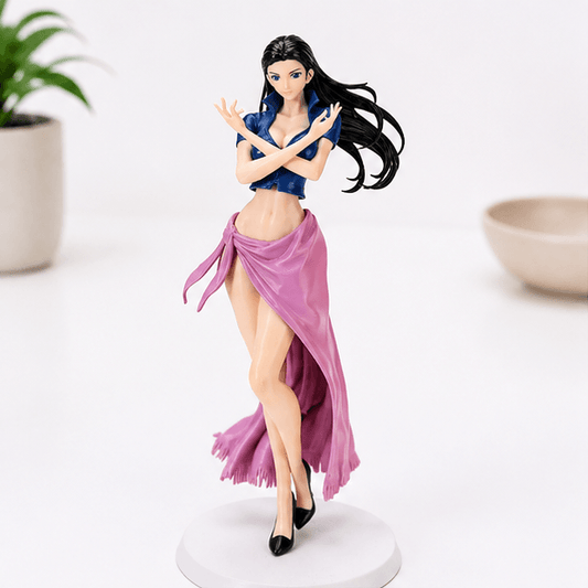 Full-length view of a Nico Robin One Piece statue standing on a round white base, wearing a blue crop top, flowing pink wrap skirt, and black heels, with arms crossed.