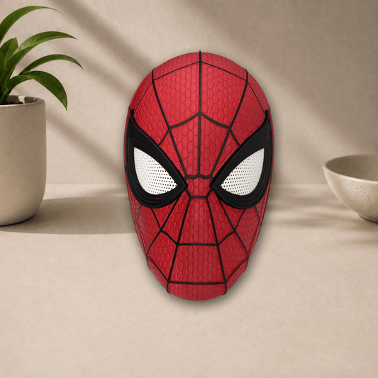 Red 3D-printed Spider-Man cosplay mask (Brand New Day style) with black webbing lines and white eye lenses, front view on a beige tabletop.