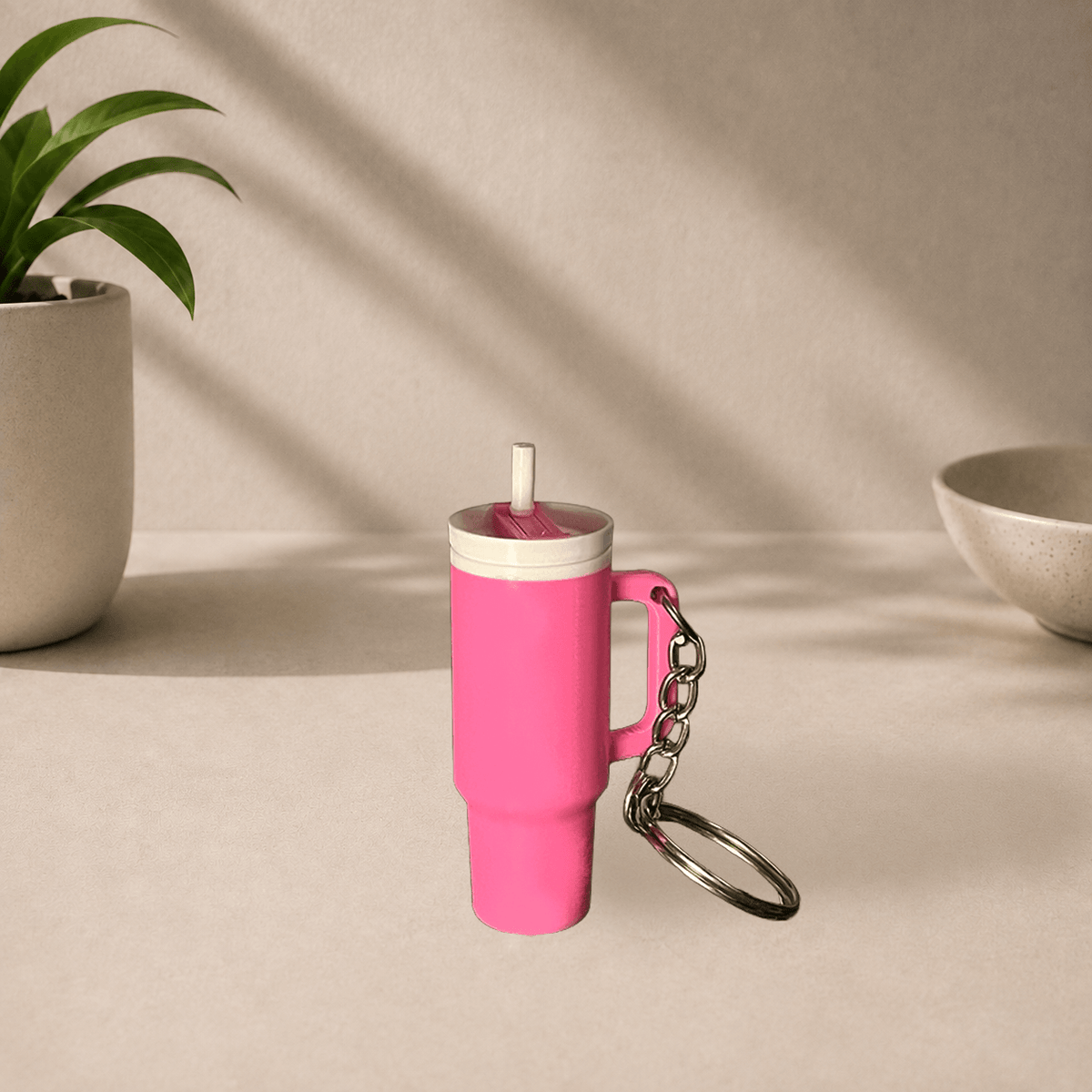 Pink 3D-printed Stanley cup-style tumbler keychain with a straw and handle, hanging from a metal keyring.