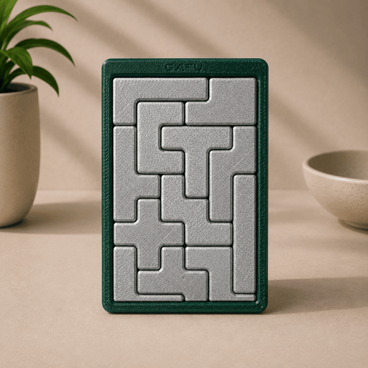 3D-printed Tetris Block Puzzle with silver interlocking tetromino pieces set in a dark green GATU-branded frame, front view.