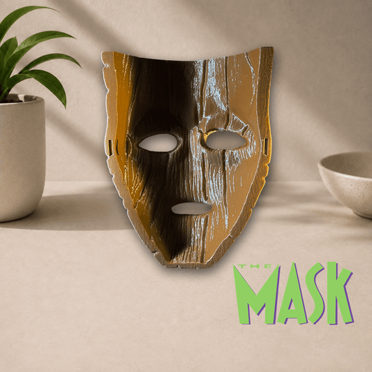 3D-printed 'The Mask' cosplay display mask in a glossy metallic gold and black finish, shown beside The Mask movie logo.