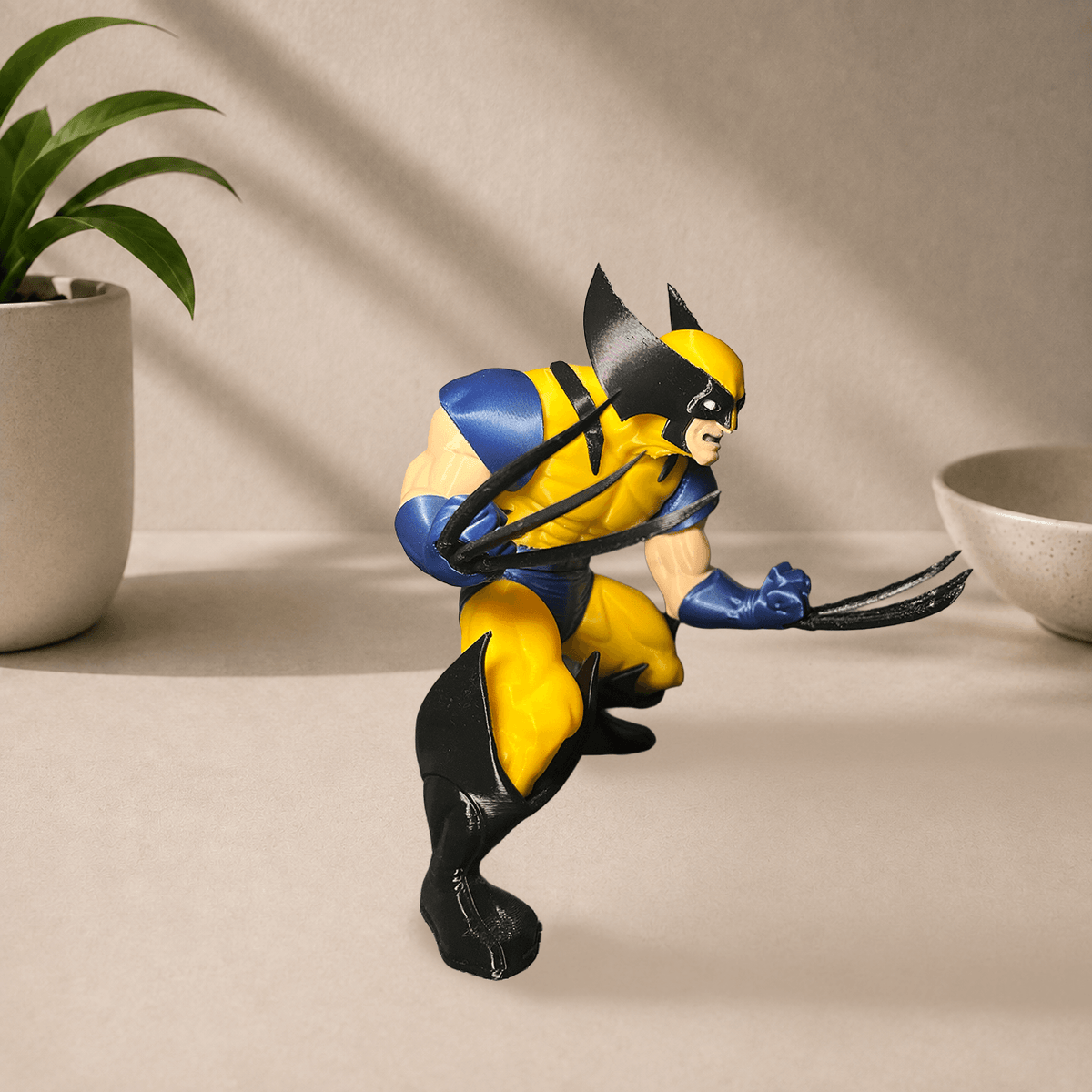 Side view of the 3D-printed Wolverine figure in a yellow and blue suit, claws extended in a fighting stance.